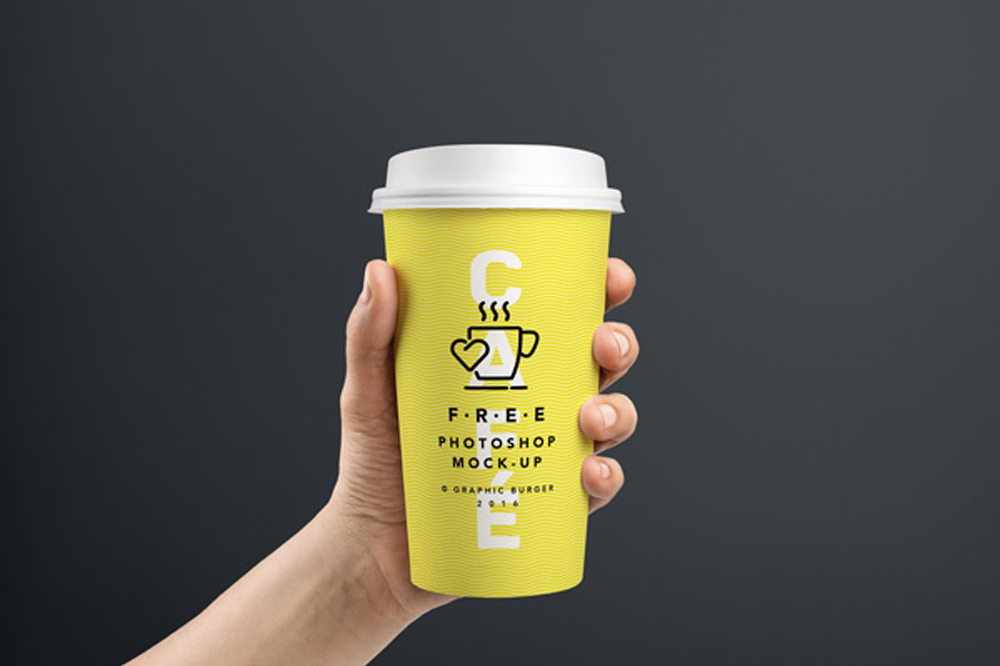 Free Coffee Cup In Hand Mockup PSD