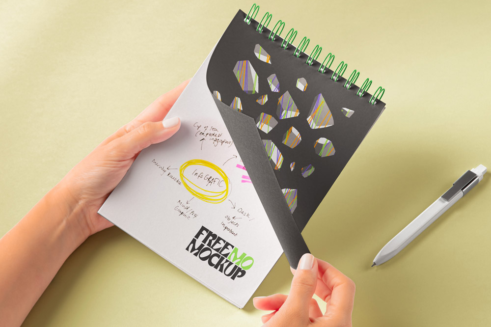 Free Hand Holding Spiral Notepad Mockup PSD