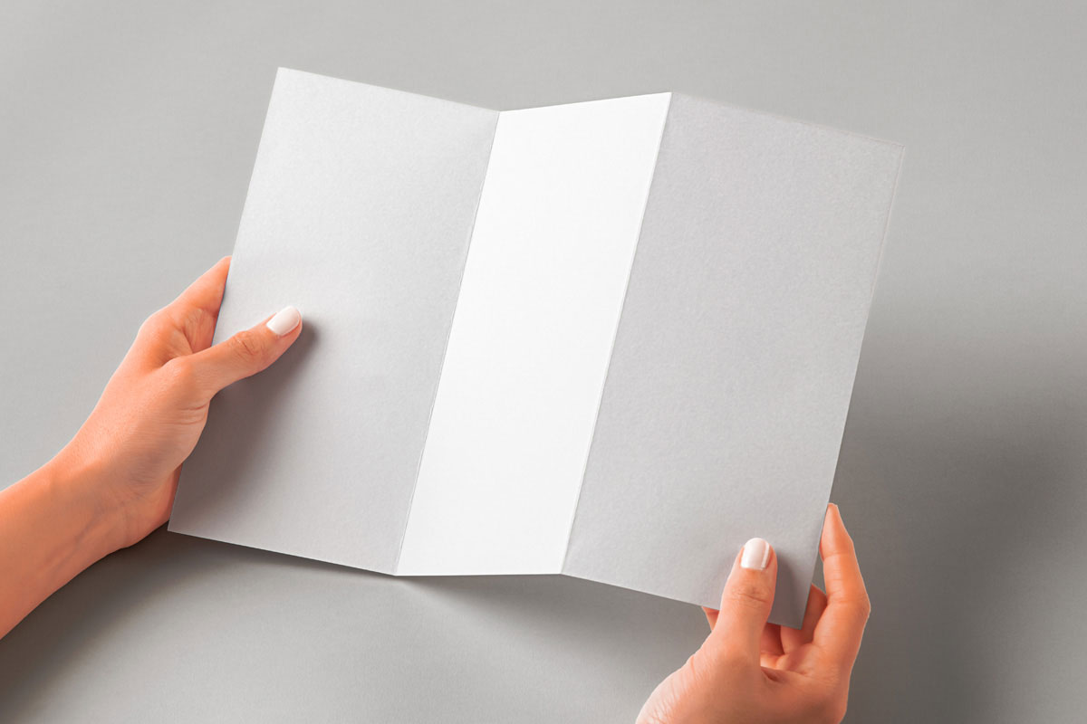 Free Hand Holding Folded Brochure Mockup PSD